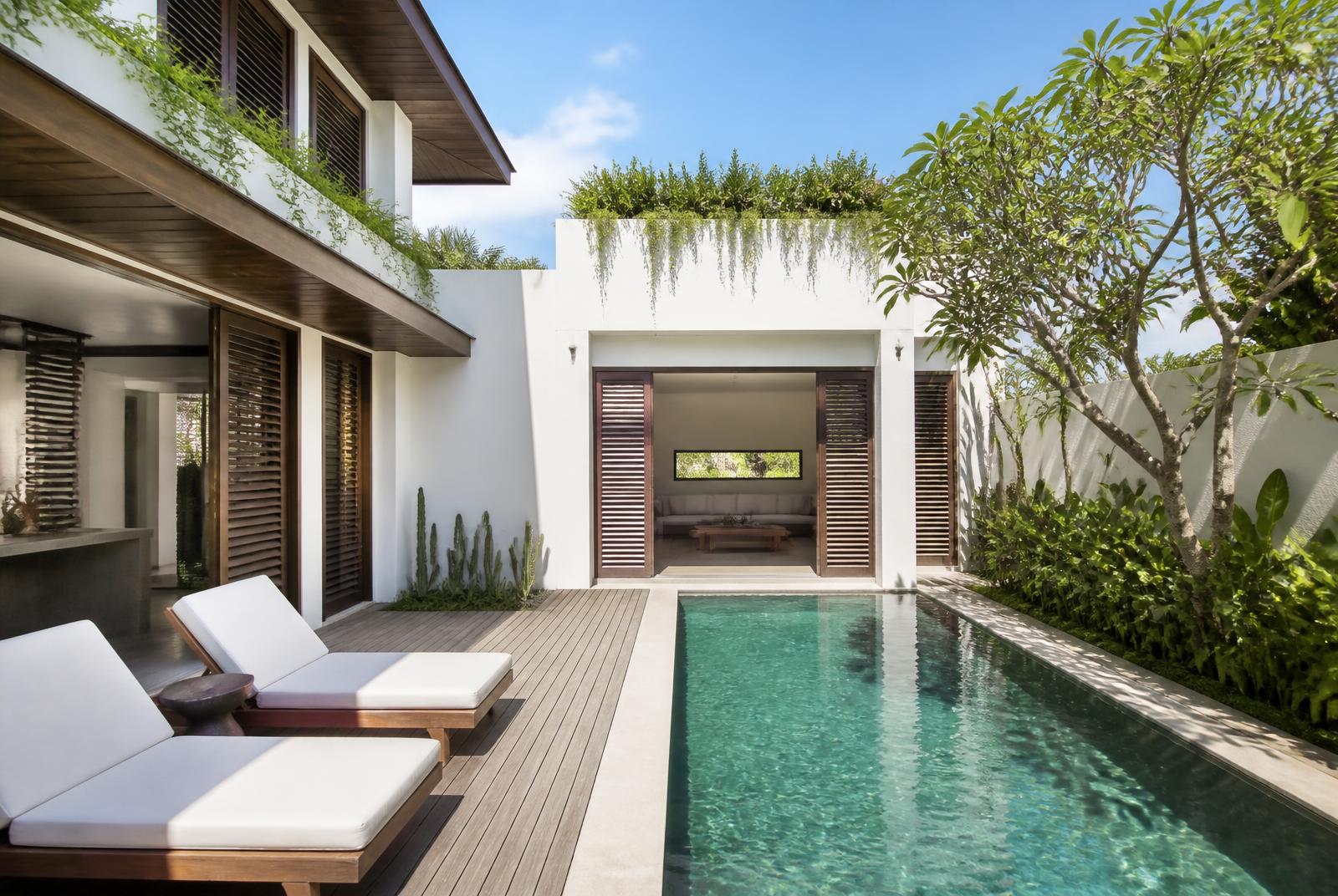 Moderne turn-key villa in Canggu met langwerpig zwembad, houten lamellen en witte gepleisterde muren
